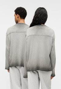 Πουλόβερ μακρυμάνικο σε γκρι απόχρωση με διαβάθμιση σκουραίσματος στο τελείωμα, με άνετη εφαρμογή και ριμπ υφή στα μανίκια και το λαιμό.