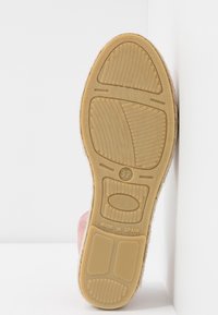 Podeszwa buta z gumowego materiału, teksturowana powierzchnia i wyraźne wzory antypoślizgowe. Jasnobrązowy kolor z oznaczeniami rozmiaru i szczegółami producenta.