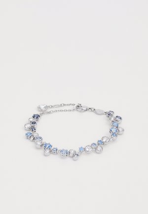 Srebrna bransoletka z mieszanymi niebieskimi i przezroczystymi kryształami w różnych rozmiarach, ułożonymi w okrągły wzór z zapięciem.