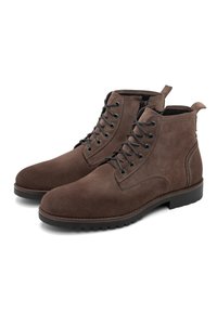 Bruine suède veterschoenen tot de enkel met een ronde neus, zwarte ogen en een gestructureerde zool. Voorzien van een lussenband aan de hak voor gemakkelijke instap.