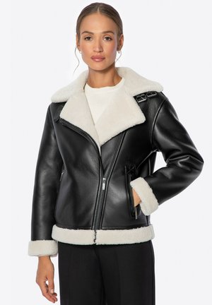Chaqueta negra de cuero con un cuello y puños de piel sintética color crema. Cuenta con un cierre frontal y detalles decorativos en los hombros.