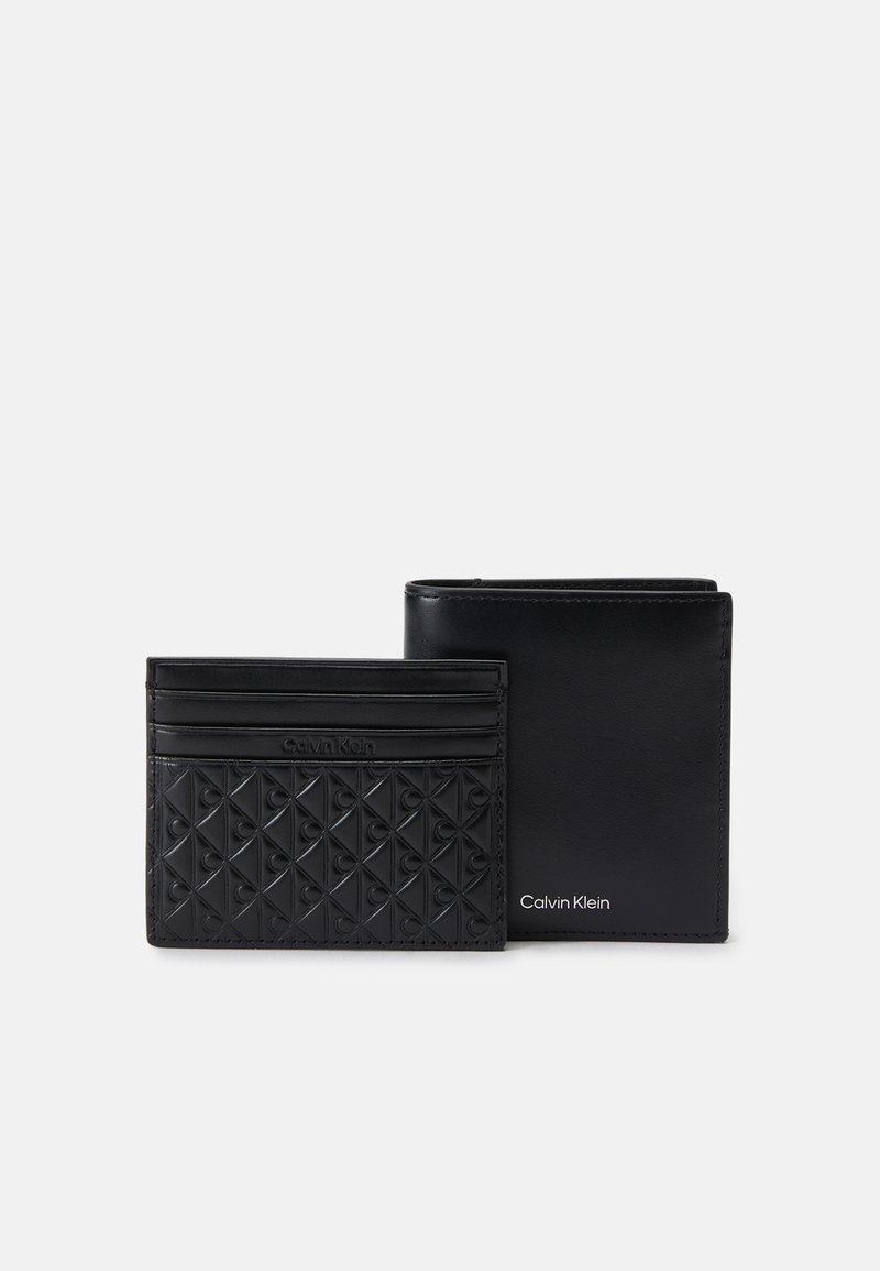 Conjunto de cartera y tarjetero de piel negra. Patrón texturizado en el tarjetero; acabado suave en la cartera. Ambos presentan el logo grabado de Calvin Klein.