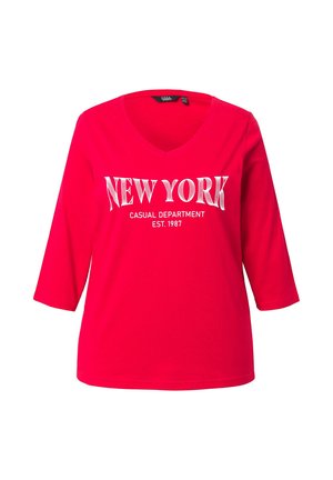 Rode katoenen T-shirt met een V-hals, voorzien van witte tekst die zegt "NEW YORK CASUAL DEPARTMENT EST. 1987" in een vetschrift. Driekwartmouwen.