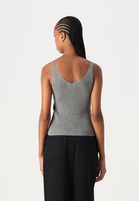 Hallide ribaga tank top, millel on sügav V-kujuline tagaosa, tehtud tekstuursetest materjalidest. Sellel on laiad rihmad ja sobiv siluett.