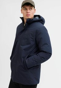 Marineblauer isolierter Parka mit Kapuze, der über einen Reißverschluss, vordere Taschen und einen glatten, wasserabweisenden Stoff verfügt.