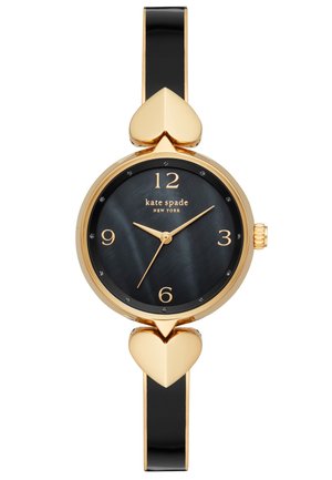 Montre-bracelet Kate Spade en or et noir avec des accents en forme de cœur, cadran noir, aiguilles dorées et index horaires numériques aux positions 12, 3, 6 et 9.