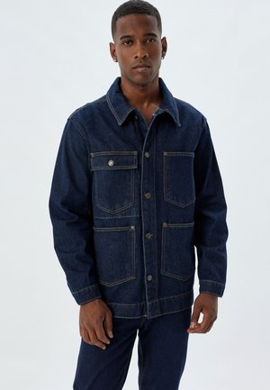 Dark denim jacket with a collar, button closure, and four front pockets. Features contrasting stitching and a relaxed fit design.
