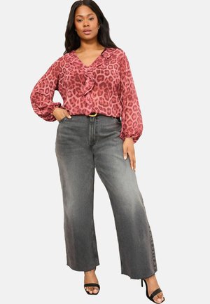 Leopard print blouse in pink tones with ruffled neckline, paired with wide-leg gray denim pants featuring a high waist. Black heeled sandals.