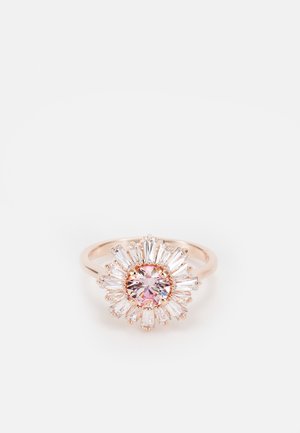 Bague en or rose avec une pierre précieuse ronde rose au centre, entourée de pierres claires taillées en baguette rayonnantes, dans un motif en rayons de soleil.