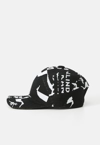 Gorro de punto negro con patrones gráficos blancos, que incluyen texto y figuras, con un visera curva y una silueta estructurada.
