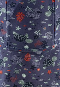 Navy fabric with sea-themed pattern featuring turtles, fish, and coral in green, red, gray, and blue hues; smooth, stretchy texture.