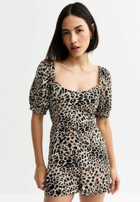 Leopardmönstrad kort klänning med puffärmar, fyrkantig halsringning och figurnära midja. Tyget har en slät textur med svart och beiget färg.