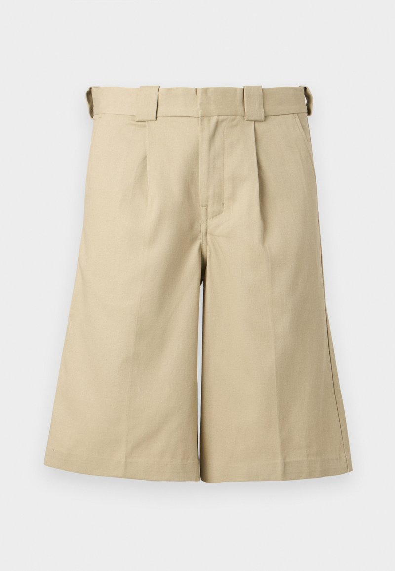 Shorts beige longueur genou avec devant plissé, passants de ceinture, poches latérales et design épuré et ajusté.