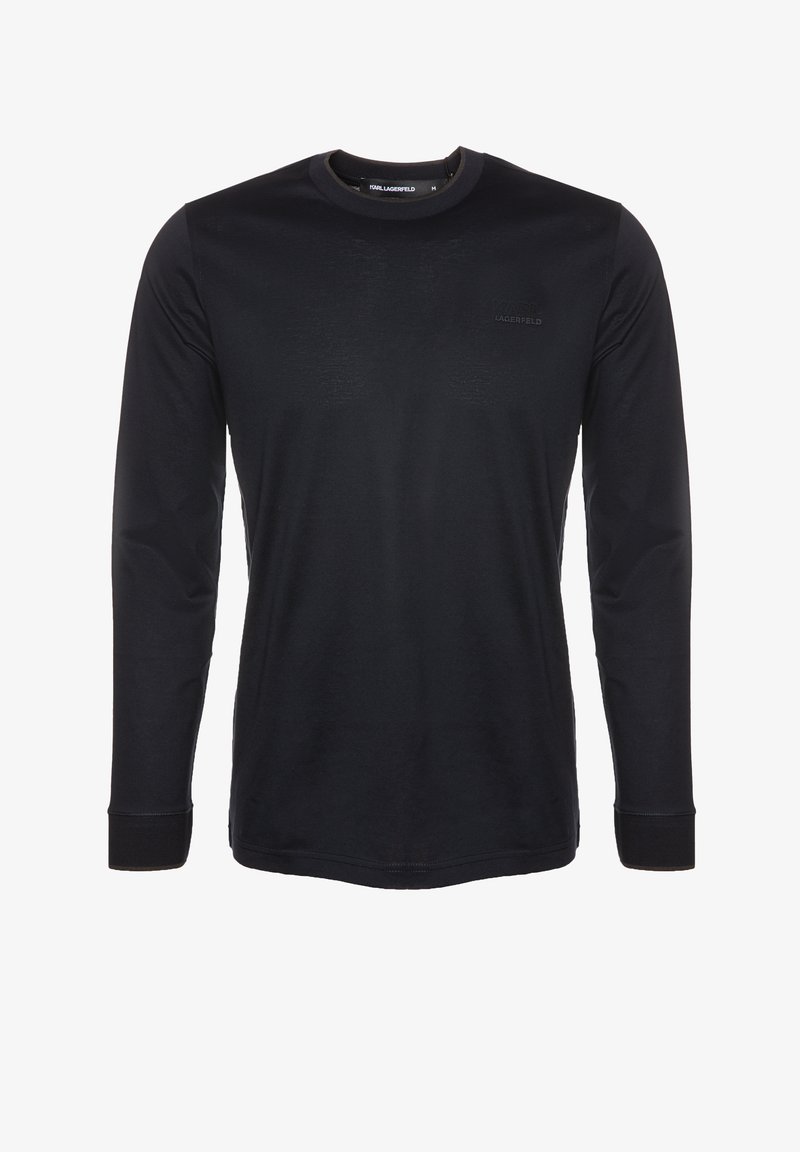 Černé tričko s dlouhým rukávem vyrobené z měkké tkaniny. Má kulatý výstřih, kontrastní manžety a diskrétní logo na prsou.