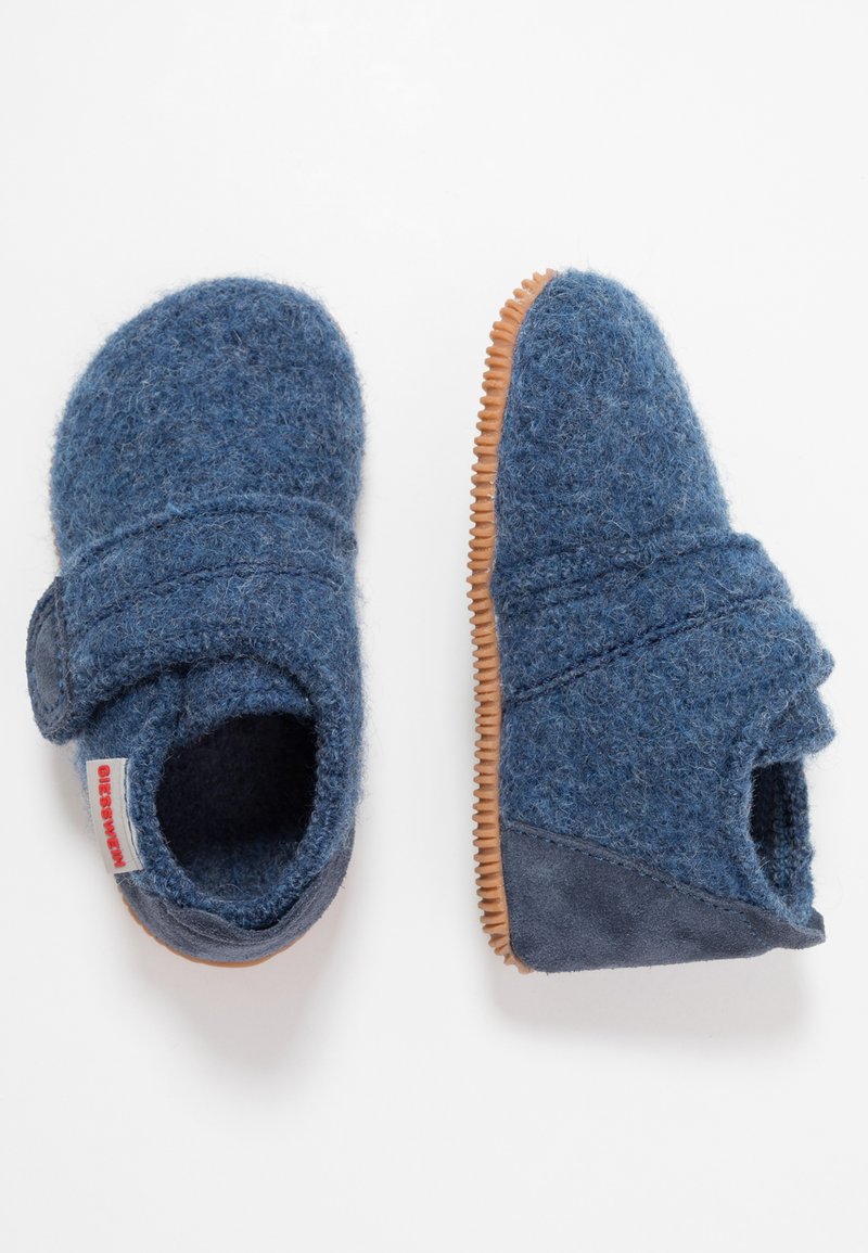 Chaussons en feutre bleu avec une semelle en caoutchouc, une sangle élastique et une texture douce. Caractéristiques : bout arrondi et design minimaliste.