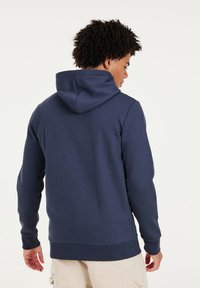Navy blue hooded sweatshirt with a soft texture, ribbed cuffs, and hem. Features a kangaroo pocket and a relaxed fit design.