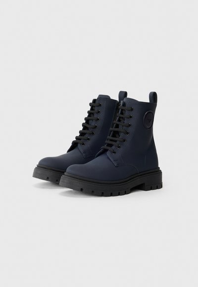 Stivaletti alla caviglia blu navy in materiale liscio, con lacci neri, suola nera spessa con trazione e dettagli con logo laterale.