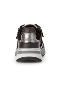 Zwarte sneaker met metallic zilveren accenten, textielmateriaal en een stevige grijze zool. Beschikt over ritsen aan beide zijden voor gemakkelijke toegang.