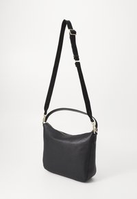 Borsa a spalla in pelle nera con una forma curva, dotata di chiusura con zip e tracolla regolabile. Texture liscia con dettagli in metallo dorato.