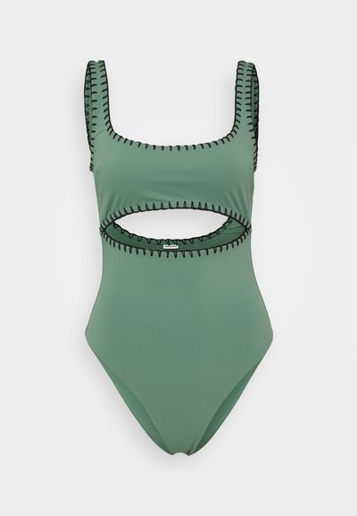 Zaļš viengabala peldkostīms ar kvadr�ātveida dekoltē, melniem šuvju akcents un izgriezumu jostasvietā. Gluda auduma tekstūra.