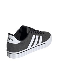 Czarno-biały sneaker Adidas z trzema białymi paskami, czarnymi sznurówkami i białą podeszwą o żłobionej strukturze.