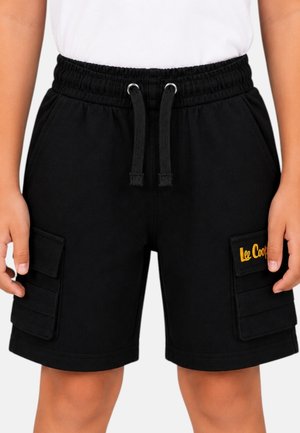 Enfant portant un short cargo noir avec taille élastique, cordons, poches latérales et écusson jaune "Lee Cooper" sur la poche droite.