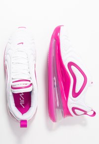 Baskets de sport blanches avec des accents roses, présentant une tige texturée, une semelle rembourrée et un design de coussin d'air transparent.