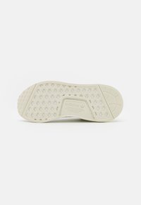 Suela de zapato Adidas, color crema, texturizada con patrones hexagonales, con el logo de Adidas y detalles de la marca grabados en el centro.
