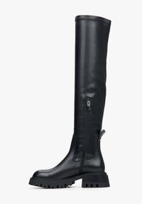Black leather over-the-knee boots with a chunky heel, side zipper, and contrasting treaded sole; smooth texture and fitted design.