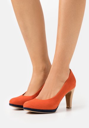 Chaussures à talons hauts en daim orange avec un bout arrondi et un accent bleu marine sur la semelle, dotées d'un talon en bois.