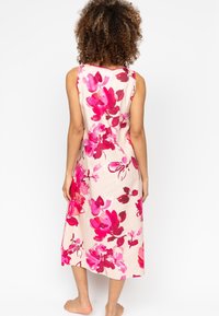 Kwiatowa sukienka maxi z miękkiego materiału, z dużymi różowymi i czerwonymi kwiatami na jasnobeżowym tle, bez rękawów, o długości do połowy łydki.