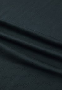Black fabric with a smooth texture, featuring a subtle pattern. The material drapes in soft, flowing folds.