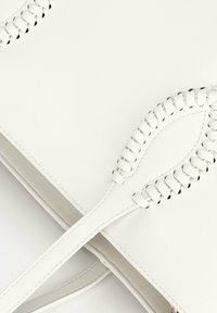 Borsa in pelle bianca caratterizzata da una superficie liscia e dettagli di cucitura intricati lungo le maniglie, con una forma rettangolare snella.
