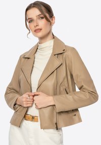 Braune Lederbikerjacke mit aufgeschlagenem Kragen, seitlichen Reißverschlusstaschen und strukturierter Oberfläche. Verfügt über eine slim fit Passform und ein kurzes Design.