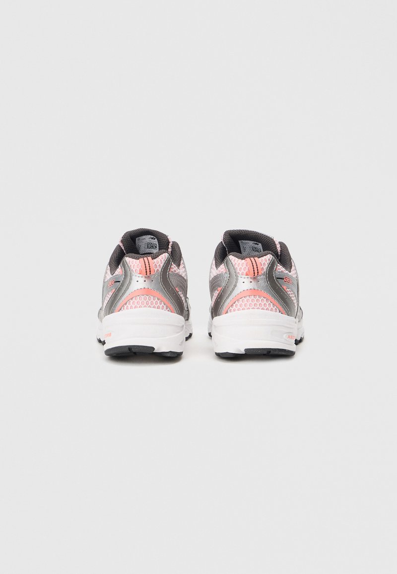 Vue arrière de chaussures de sport avec un dessus en mesh gris et rose, un col rembourré, et une semelle blanche avec des accents noirs.