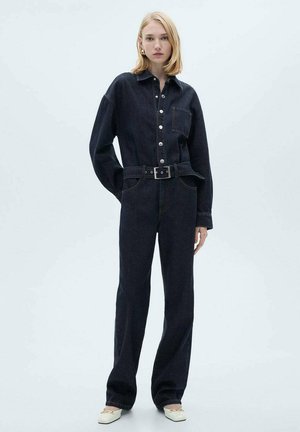 Combinaison en denim foncé avec col, boutons sur le devant et taille ceinturée. Présente des jambes larges et une surface texturée.