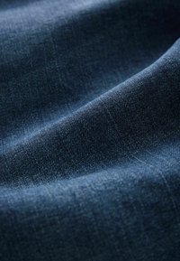Țesătură de denim albastru închis, cu o textură netedă, având variații ușoare de nuanță și modele subtile de țesut.