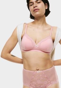Rosa underklädesset med en behå med spetskant, formade kupor och justerbara band, ihop med höga spets- och nätshorts.