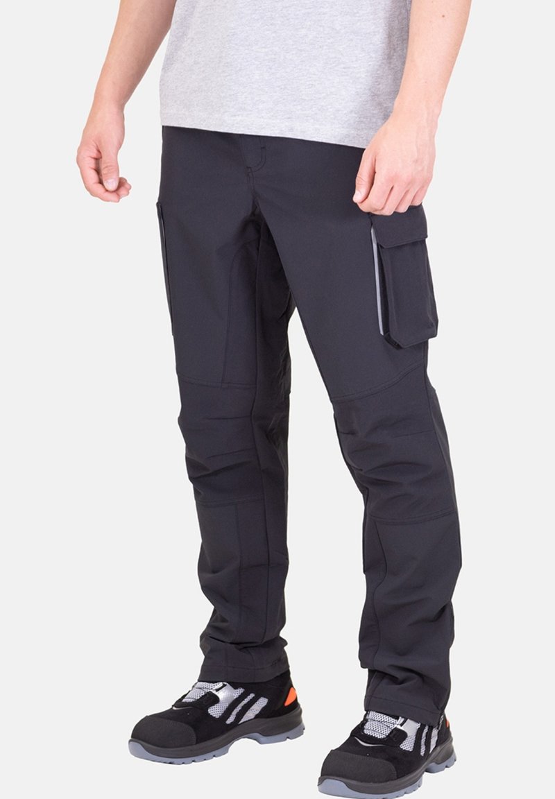 Schwarze Cargo-Hosen aus robustem Stoff, mit Seitentaschen, verstärkten Nähten und geradem Bein-Design. Getragen mit schwarzen und grauen Schuhen.