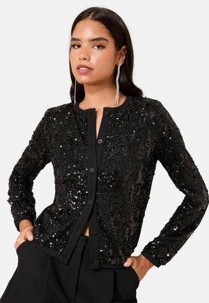 Black sequin cardigan with long sleeves, button front, ribbed cuffs, and hem. Features a textured surface of overlapping sequins.