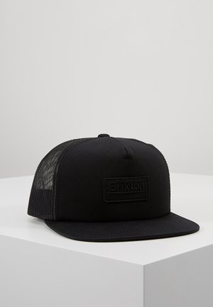 Casquette camionneur noire Brixton avec dos en filet et visière plate, présentée sur une surface blanche contre un fond gris.