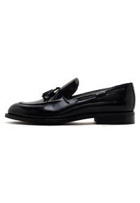 Mocassin en cuir noir avec des glands, bout rond, couture contrastante et un talon de hauteur moyenne. Texture lisse et finition polie.