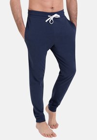 Pantalons de jogging bleu marine en mélange de coton doux, dotés d'une taille avec cordon de serrage, de poches latérales et de bas de jambes effilés.