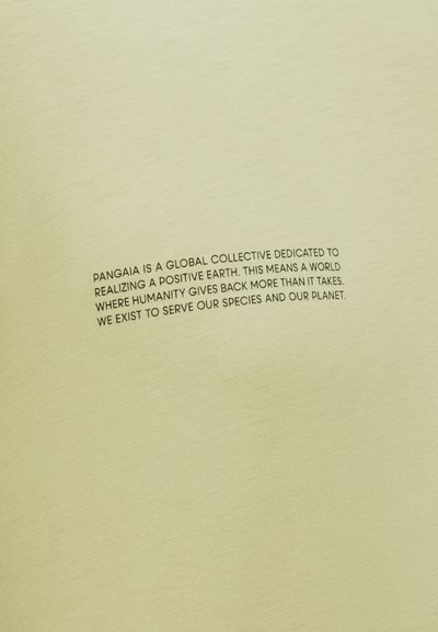 Κείμενο σε μπεζ ύφασμα δηλώνει ότι μια παγκόσμια συλλογικότητα στοχεύει σε μια θετική Γη όπου η ανθρωπότητα επιστρέφει περισσότερα απ' ό,τι παίρνει.