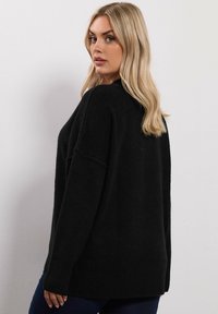 Czarny, oversize sweter wykonany z miękkiej dzianiny. Ma luźny krój, ściągacze przy mankietach i u dołu oraz prosty, jednolity design.