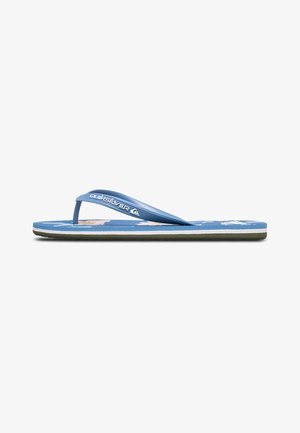 Des tongs bleues avec un semelle texturée, des fines lanières et un logo blanc. Présentent des motifs floraux sur la semelle intérieure, semelle extérieure noire.