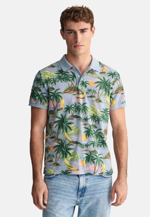 Polo tričko s modrým pozadím a vzory tropických palm a západu slunce. Krátké rukávy, límec a měkký bavlněný materiál.