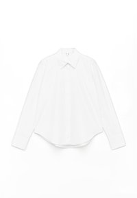White long-sleeve shirt made of cotton, featuring a pointed collar, front button closure, and rounded hem with wide cuffs.