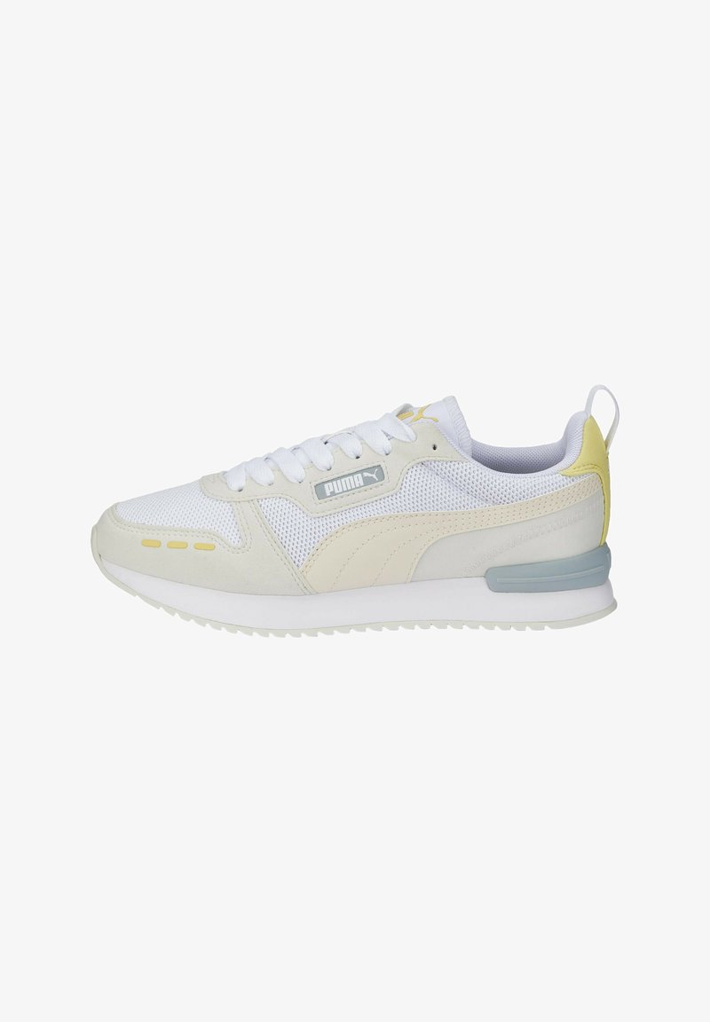 Hvide sports sneakers i mesh og ruskind, med en lys gul accent, grå branding og en polstret sål.