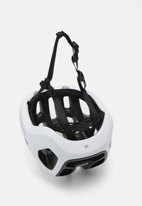 Un casco de bicicleta blanco visto desde el interior, con correas ajustables negras y aberturas de ventilación sobre un fondo blanco.